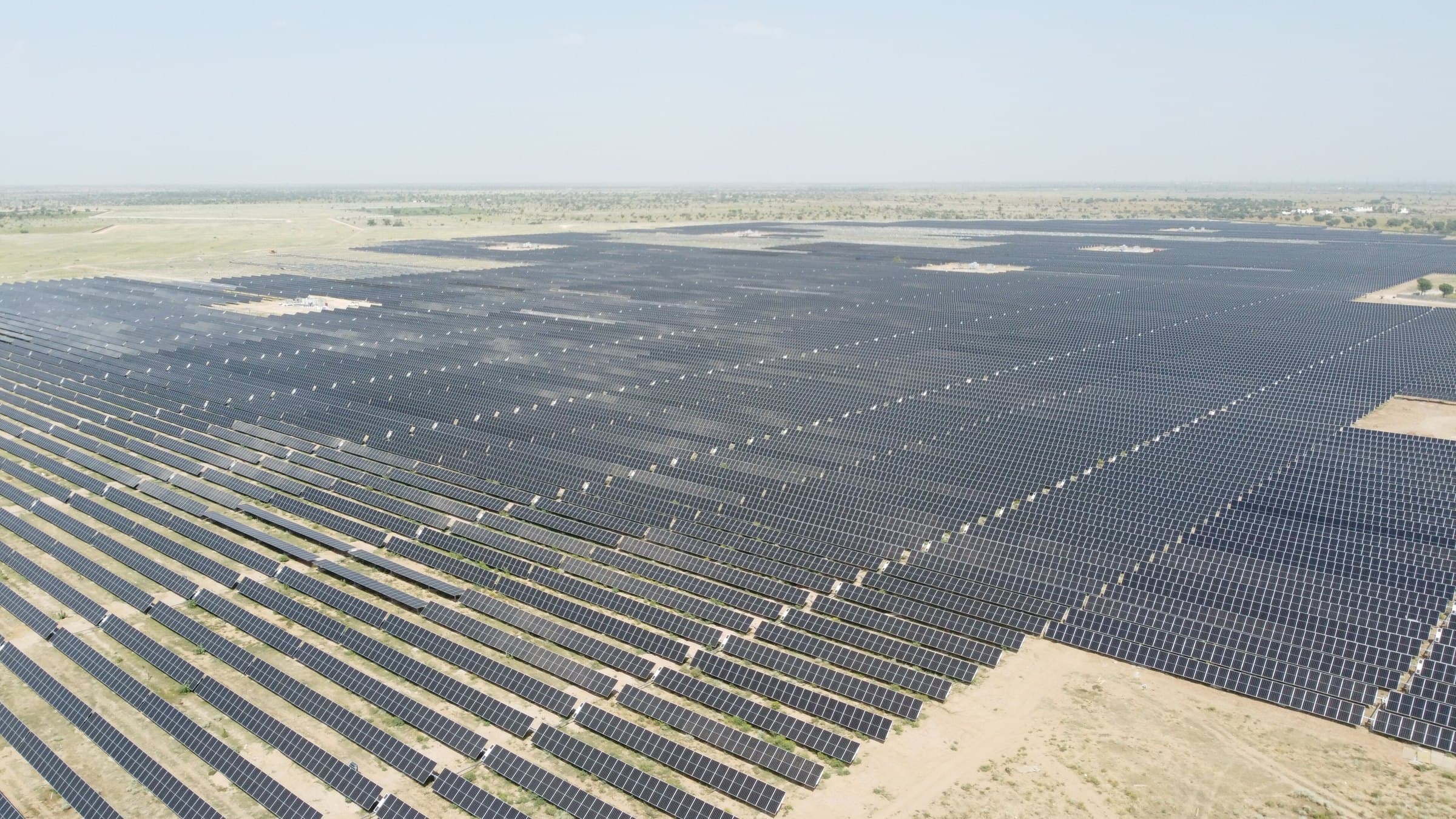 Vista aérea de um mar de painéis solares que se estende até o horizonte em Bhadla, na Índia.