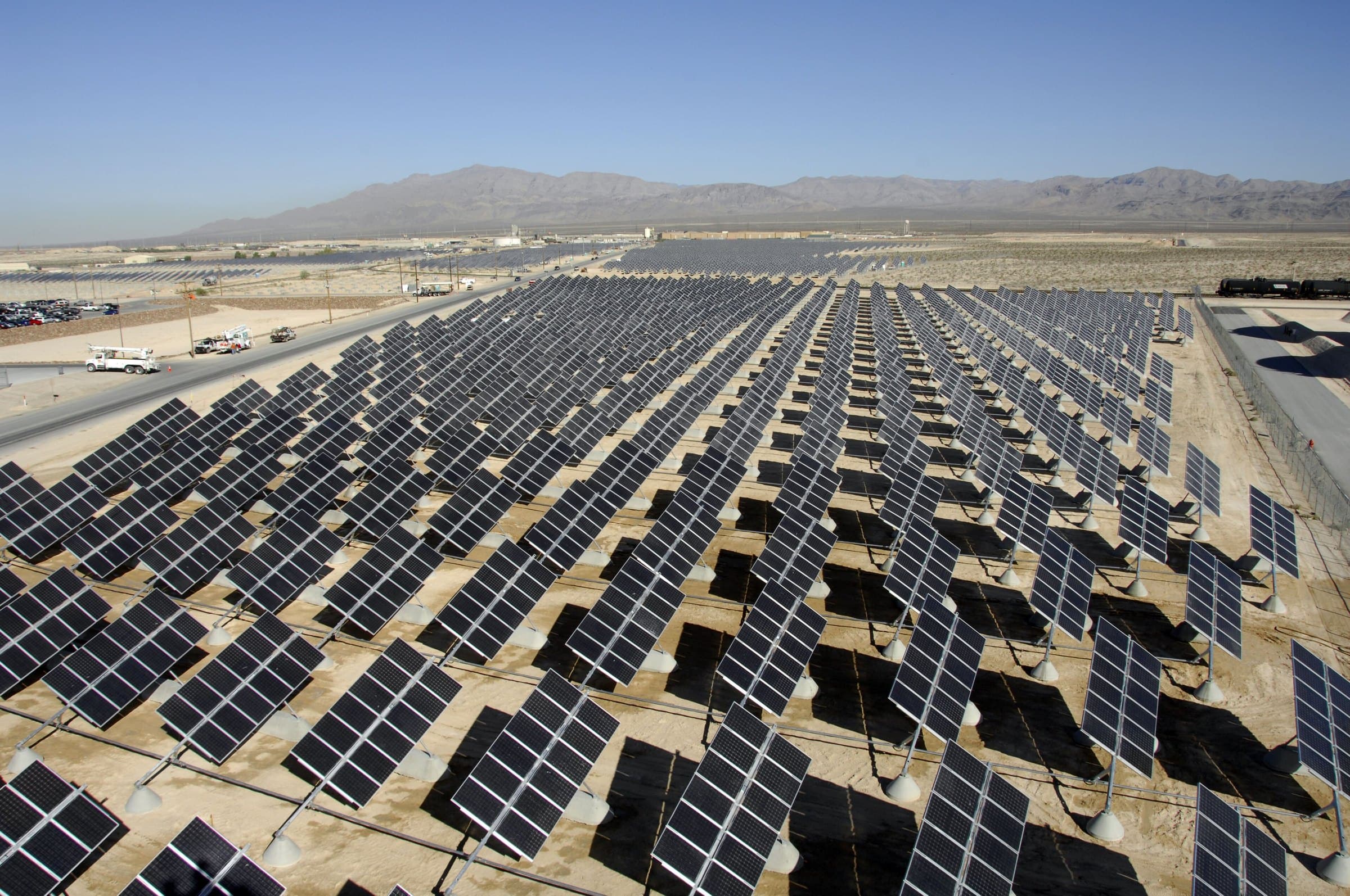 Milhares de painéis solares com rastreadores no deserto de Nevada, com montanhas ao fundo.